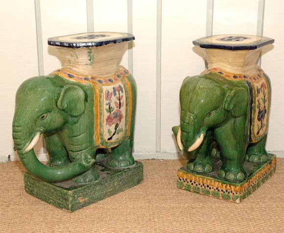 Two hand painted porcelain elephant garden stools. Flower detail in color on one base. The base is green--pair not identical.