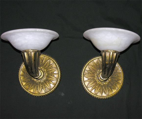 A pair of one-armed deco-style wall sconces in cast bronze with alabaster uplight shades, modern.