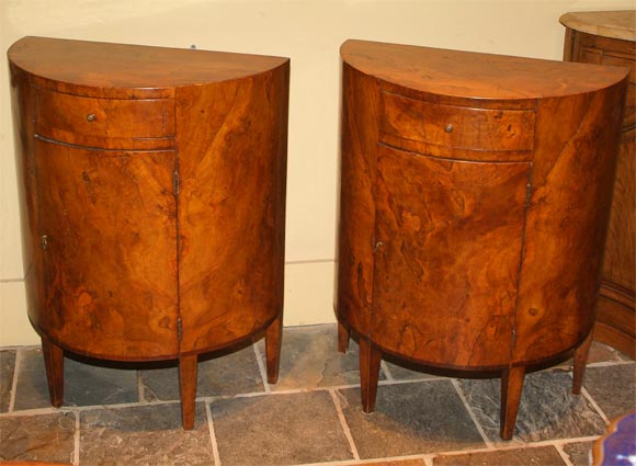 Pair of Italian neoclassical walnut demi-lune commodes, eahc of plain D form, fitted with a frieze drawer above a panel door raised on straight tapering legs