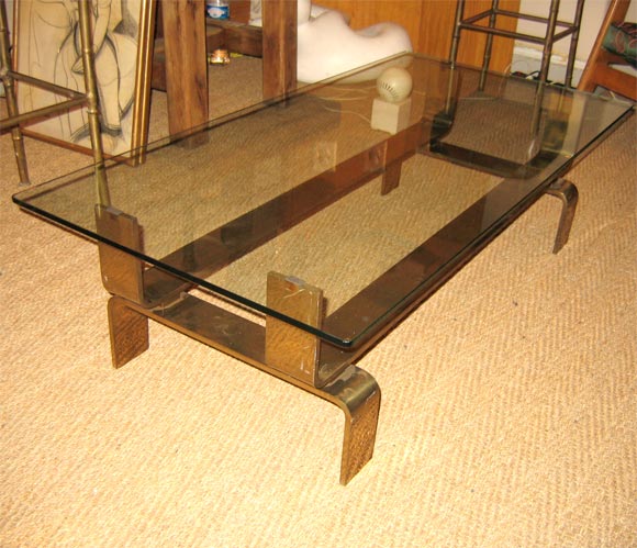 1950 rectangular coffee table with glass top and gilt bronze base structure.