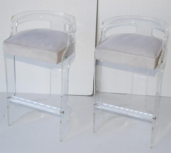 Pair of lucite bar stools of semi-circular form with cut-outs at top and bottom and seats upholstered in original white cotton velvet.