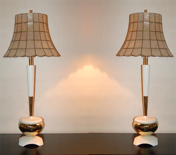 High style pair of white lacquered and brass table lamps with vintage capiz shell shades.  Dating to the 1950's, removed from a Palm Beach estate. 24 HOUR HOLD ONLY.