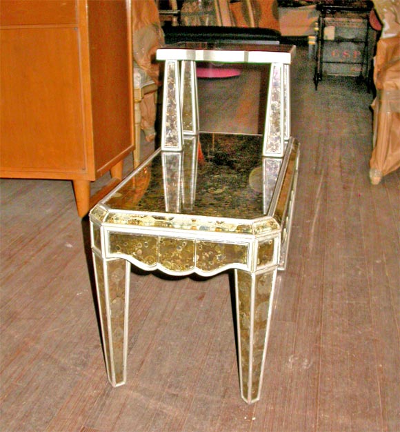 Pair of two tiered mottled, beveled, mirrored glass end tables. The lower surface has a scalloped apron on three sides.