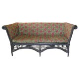 Antique even arm wicker settee with original arts and crafts fabric