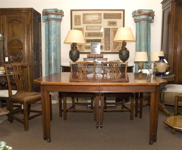 A Sheraton style table in mahogany with string band inlay and canted corners over tapered legs, with five leaves.