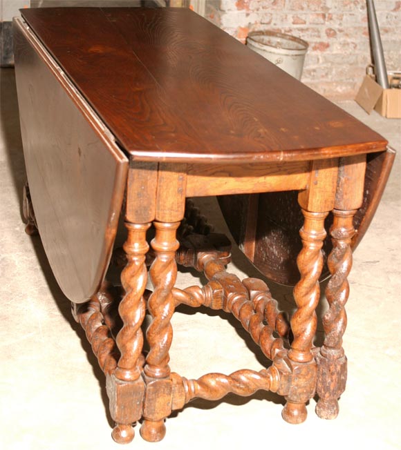 A very generous oval gateleg table of beautiful chestnut with robust barley twist carved legs. When fully open it can seat up to ten. Measure: The table fully open is 62 x 68.