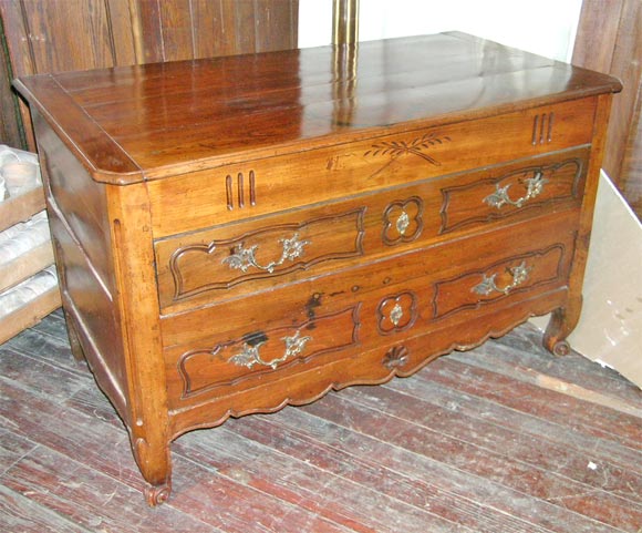 A two-drawer walnut Sea Captain's commode with<br />
cabriol legs, original brass drawer pulls and incised<br />
decorative carving on front apron and drawers.