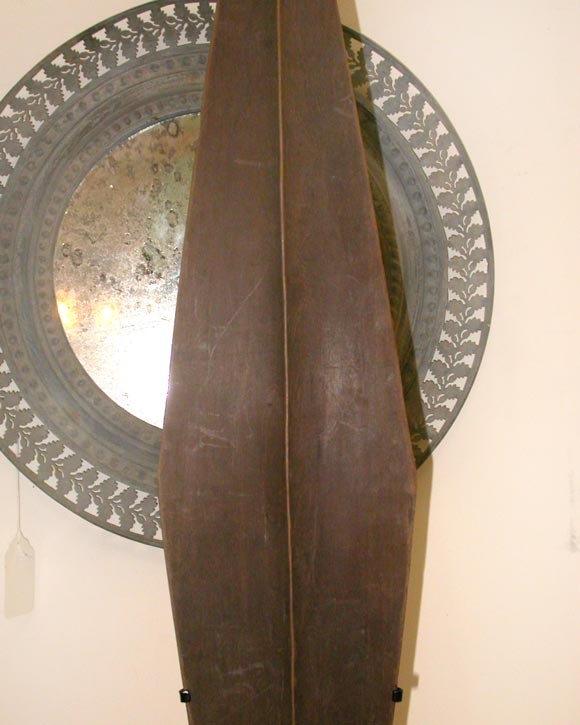 2 oars and a fan from the Mentawai Islands in Indonesia.  Each one is hand carved from a single piece of wood and has been mounted on a stand.  The fan is also made from wood and has rattan stitching on the face.
