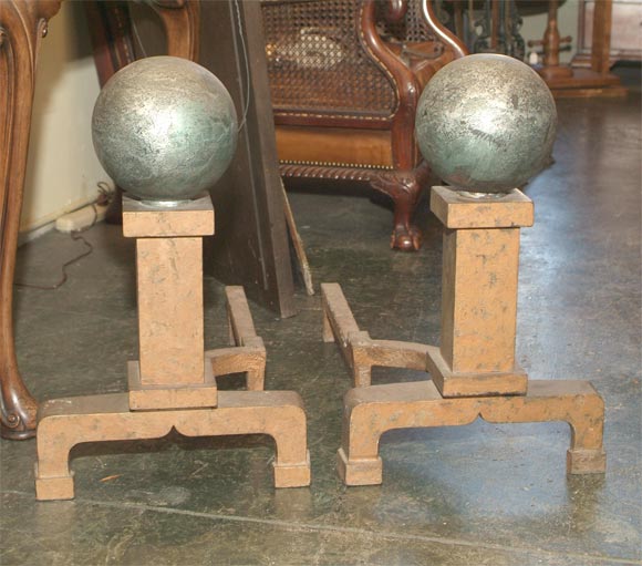 Impressive Pair of Arts and Crafts Cast Iron Andirons with silvered canon ball atop square column.  Traces of old copper and silver paint.  American, Circa 1900.
