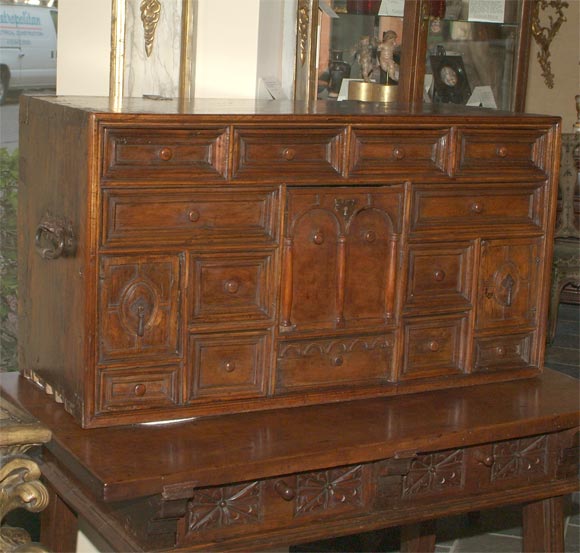 Spanish baroque walnut vargueno, the rectangular top above a number of arched drawers and small panel doors, with wrought iron carrying handles on each side.