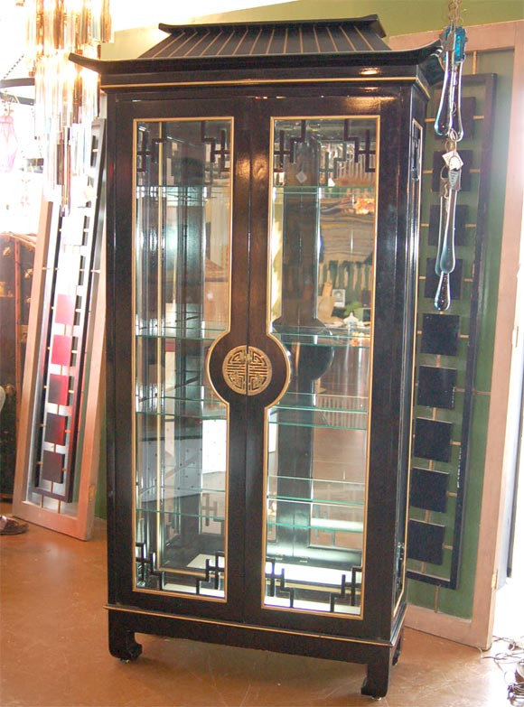 Oriental style black lacquered cabinet that lights from the top and the bottom.