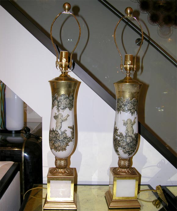 Pair of reverse painted and decoupage glass table lamps featuring cherubic decor against a white background.