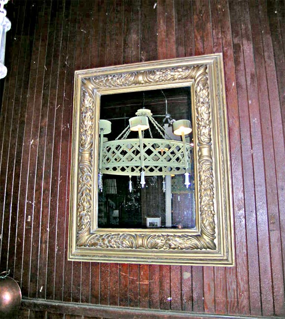 Miroir encadré en bois sculpté et doré. Le miroir est plus récent.