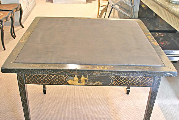 An English black chinoiserie folding games table with black moire fabric insert