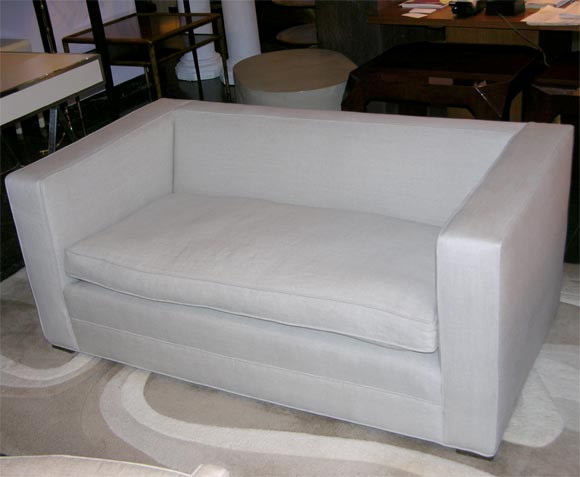 Two-seater upholstered sofa with loose seat cushion, raised on square wooden feet.  Recently upholstered in Belgian linen.
