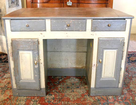 An 18th century French painted three-drawer desk. It has a leather top and two doors. The knee hole is very small, as in the period one sat sideways with only the right knee under the desktop.