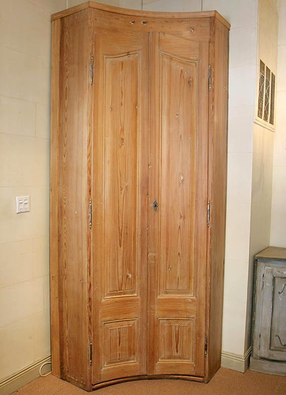 Zwei konkav getäfelte Türen öffnen sich zu Regalen und einem Unterschrank.