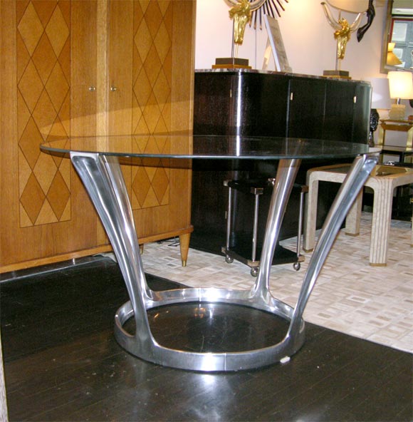 Fantastic cast aluminum dining table by Boris Tobacoff. Each arm is a solid cast aluminum piece linked together at the bottom. Original glass top. Two identical tables available. Price for one.
