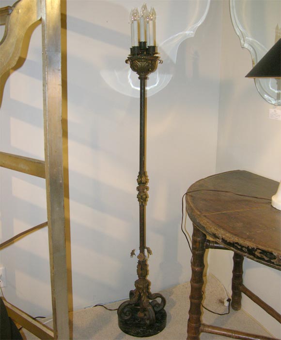 A pair of burnished tole and iron 5-light torchieres on round, marble bases.