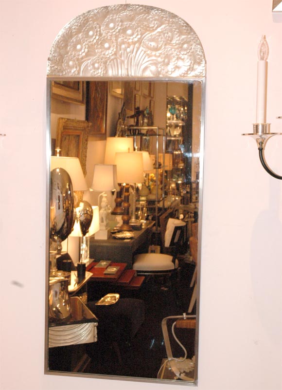 A rare and unusual wall mirror with nickeled metal frame supporting a Rene Lalique trumeau panel of glass at the top featuring a spray of flowers.  Panel is signed with 