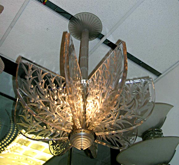 Lalique chandelier, clear and frosted glass molded with  stylized eucalyptus leaves and fruits, composed of eight lateral panels, pendant from a cental post covered with original glass segments and canopy. <br />
A rare and important chandelier,