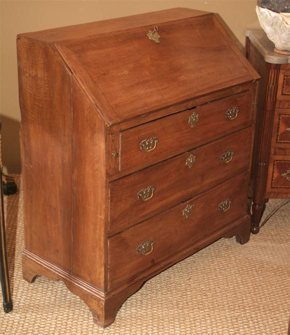American Chippendale walnut fall-front secretary, the slant front opening to a plain writing surface and eight maple-banded drawers flanking shaped cubbyholes and a shelf, all above three long drawers raised on bracket feet.