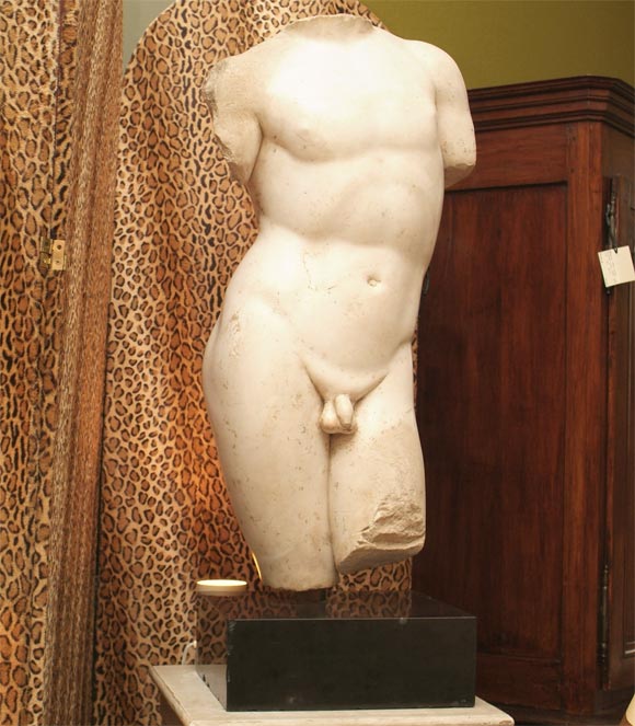 Roman Parian marble torso of a male athlete or deity, a vigorous figure rendered in classic contrapposto, of warm gently weathered patina, raised on custom black marble plinth base.