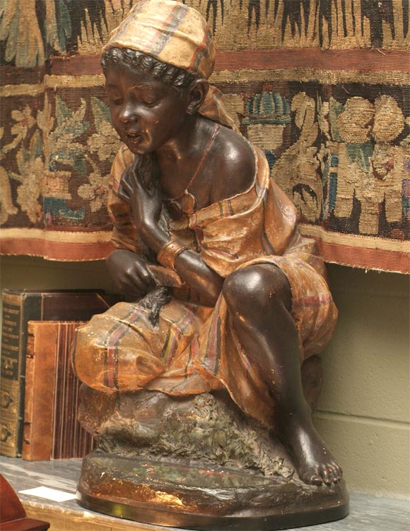 Large-scale Italian handpainted figure of a Nubian girl, beautifully rendered kneeling beside a pool (of imbedded floral-painted mirror glass) to gaze at her reflection while combing her hair; signed and dated 