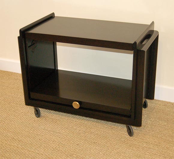 Paul Frankl for Brown Saltman ebonized mahogany serving cart.<br />
Bottom shelf can be raised to double the tabletop to 36