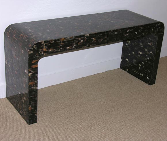The simple waterfall shaped console decorated with rectangular pieces of horn, set with two draws.
