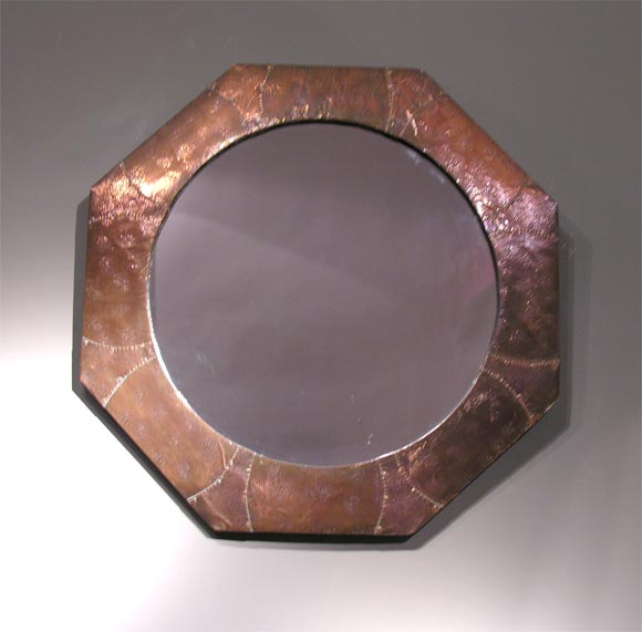A bold example of mid 19th C Arts & Crafts hand-hammered and peened copper metalwork in the form of an octagonal decorative mirror. An inventive and original hand made design.