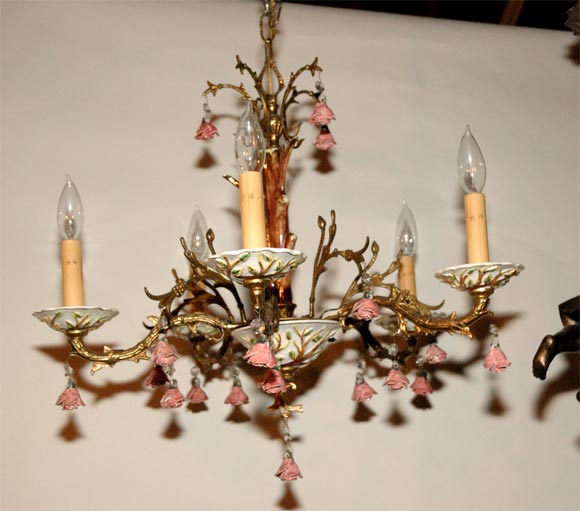This five light chandelier has character and a garden look. The cast elements are in the form of tree rose branches and support the pink roses and hand painted candle cups. Jefferson West Antiques offer a variety of chandeliers and other lighting