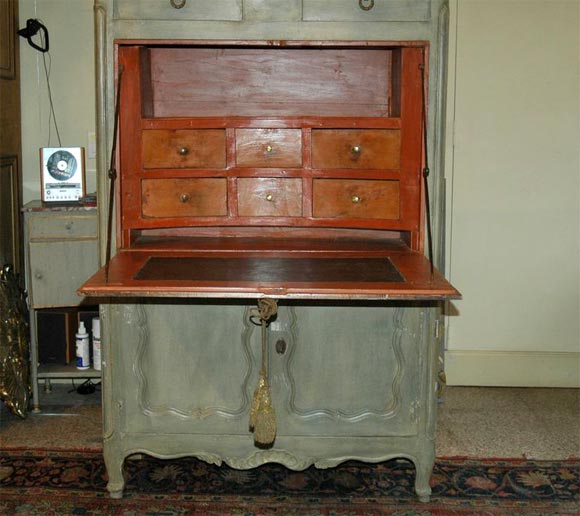 A classic abattant with six interior curved drawers, the hardware supporting the leather lined drop down is the original wrought iron. There are two drawers above and two doors below the drop with one interior shelf. The exterior is painted a soft