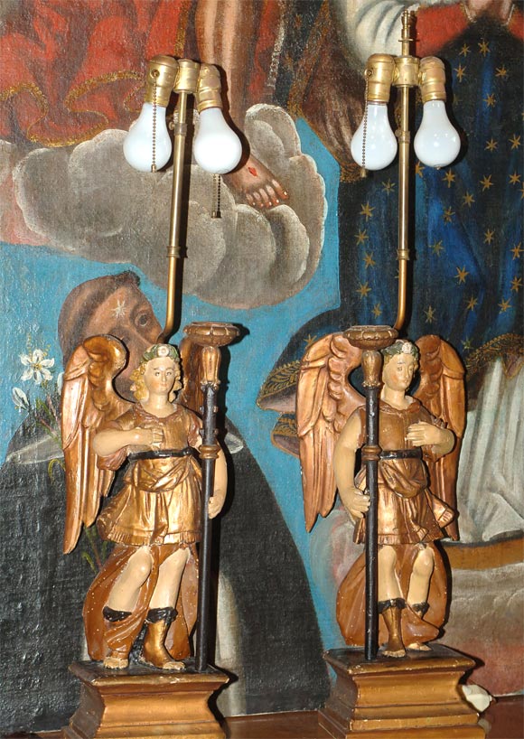 Pair of Spanish Colonial carved and painted wood angel candleholders converted into lamps.  Lampshades are available.  Dimensions below are for the entire lamp structure.  The angel figures themselves are 20.5
