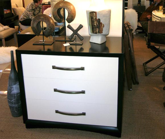 A pair of chests by T.H. Robsjohn-Gibbings with original brass hardware. The chests have been refinished with ebonized cases and white lacquer drawer fronts.