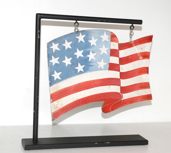 PATRIOTIC TIN FLAG USED FOR HANGING IN THE WINDOWS DURING PATRIOTIC HOLIDAYS SUCH AS : THE FOURTH OF JULY,MEMORIAL DAY,PRESIDENTS DAY AND OTHER HOLIDAYS.THIS IS QUITE RARE AND IN PRISTINE CONDITION.THIS FLAG WAS HUNG BY THE TWO ORIGINAL ROUND WIRES