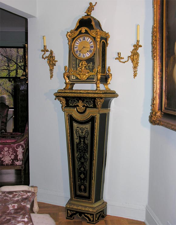 Exceptional Louis XIV ormolu-mounted Boulle marquetry cartel (striking bracket clock) on a Louis XIV ormolu-mounted ebonized and brass-inlaid Boulle tapering pedestal. The cartel case with finial of putto on a globe, on four caryatid feet, the cast