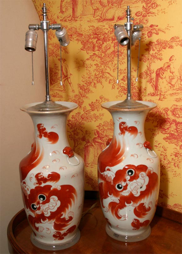 A PAIR OF HAND PAINTED CHINESE VASES WITH FOO DOGS IN THE CLASIC RED-ORANGE, MOUNTED ON A ACRELIC BASE. MEASUREMENTS ARE FROM THE TOP OF THE VASE, 22