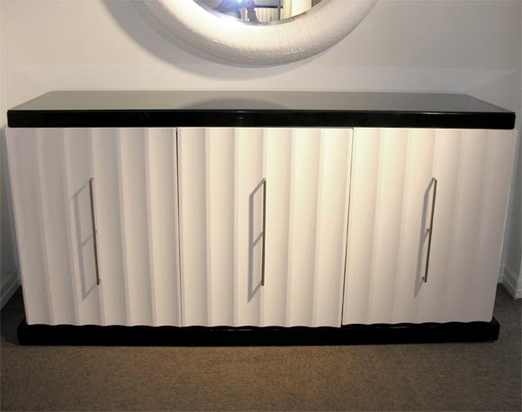 Spectacular 3-door credenza, scalloped all around in white lacquer with black lacquer base and top, designed by Tommi Parzinger for Parzinger Originals, American 1960's (branded Parzinger Originals in drawer)<br />
Nickel hardware