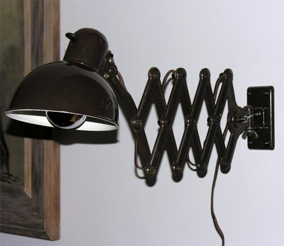 Model #6718, produced by Kaiser & Co.  Wall-mounted lamp made of black painted metal with extending gate-fold mechanism.  Original bakelite switch.  *This lamp can also swivel up and down as well as side to side.  Christian Dell was the head of the