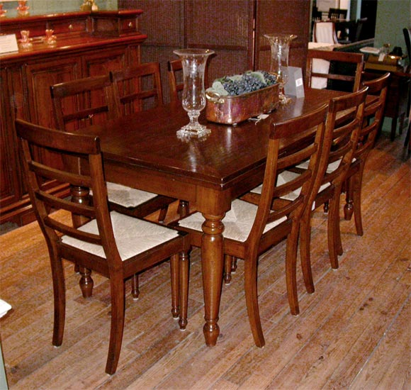 Solid walnut dining table with turned legs and self-storing leaves.  Table can seat up to 12.  Custom sizes and finishes available upon request.