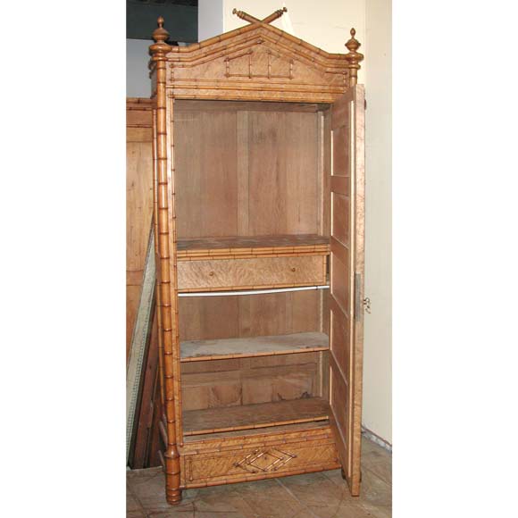 A 19th century Armoire in cherry and birch wood faux bamboo with a central drawer and two upper and two lower bamboo facade shelves.