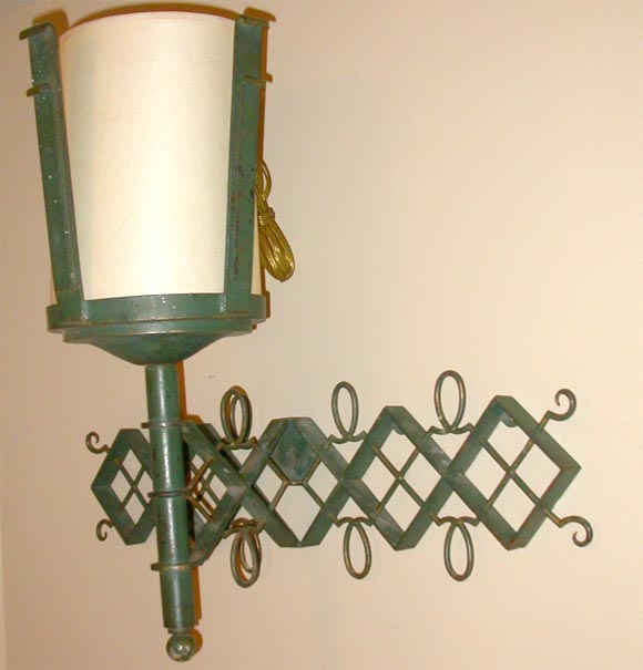 Green painted wrought iron torch-form sconces with original paper shades. Inspired by the designs of Jean Royere. Torch is attached to the trellis-like bracket.