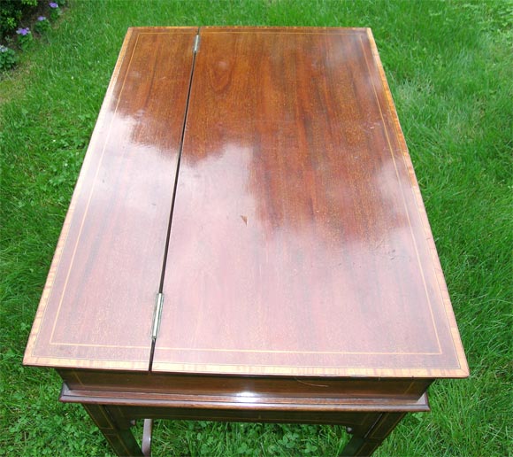 Raised platform with ten cubbyholes on top; calendar frame; stop watch; schedule frame; and two drawers with brass pulls, which drop into a top compartment which, in turn, folds into a base compartment containing a leather writing surface with brass