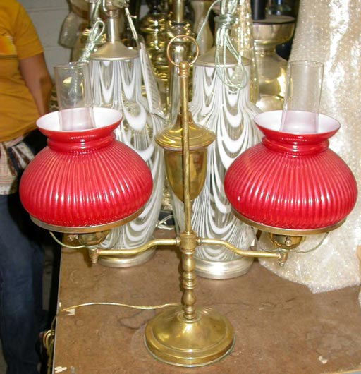Electrified oil-burning brass student's lamp.  Bears original oil resevior and ribbed red glass globes.