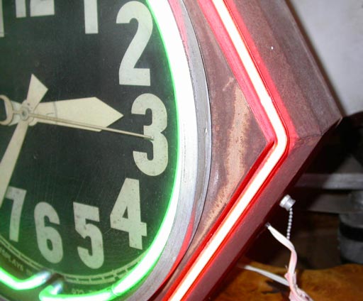 Hexagonal metal cased electric clock with red and green neon trimming, chain hung