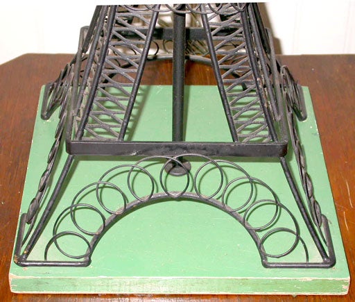 Individual Eiffel Tower-inspired iron lamp on a conforming painted wood base.