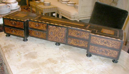 An lovely ebonized and inlaid desk organizer, 18th century, French. On bun feet, it has a center door and eight drawers.