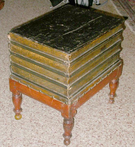 A painted faux book table on mahogany base with leather hinged top