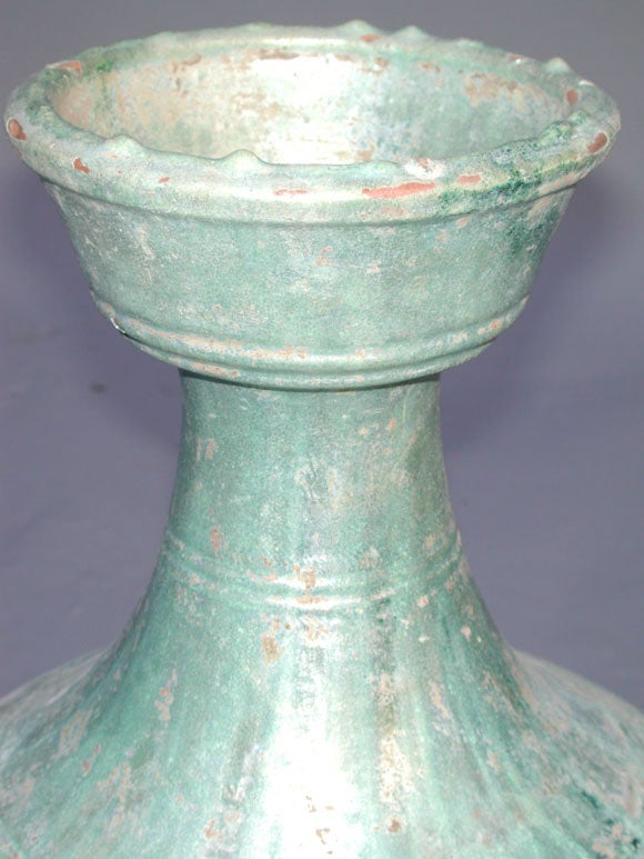 A STUNNING AND UNUSUAL CHINESE IRIDESCENT SILVERY-GREEN GLAZED RED POTTERY BALUSTER-FORM JAR (HU).  The gracefully flared neck with a large cup-shaped mouth over a bulbous body highlighted by concentric raised bands; flanked by well-delineated